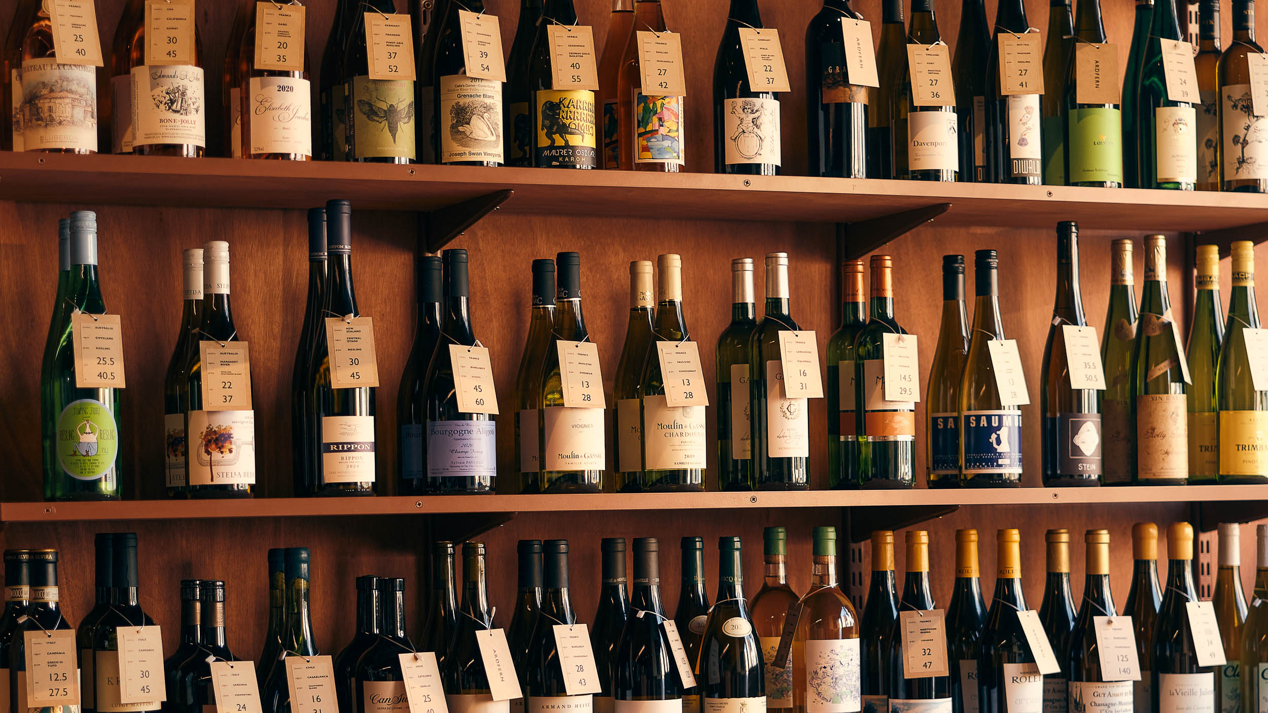 The wine wall at Ardfern — shelves of bottles from the 100-plus list