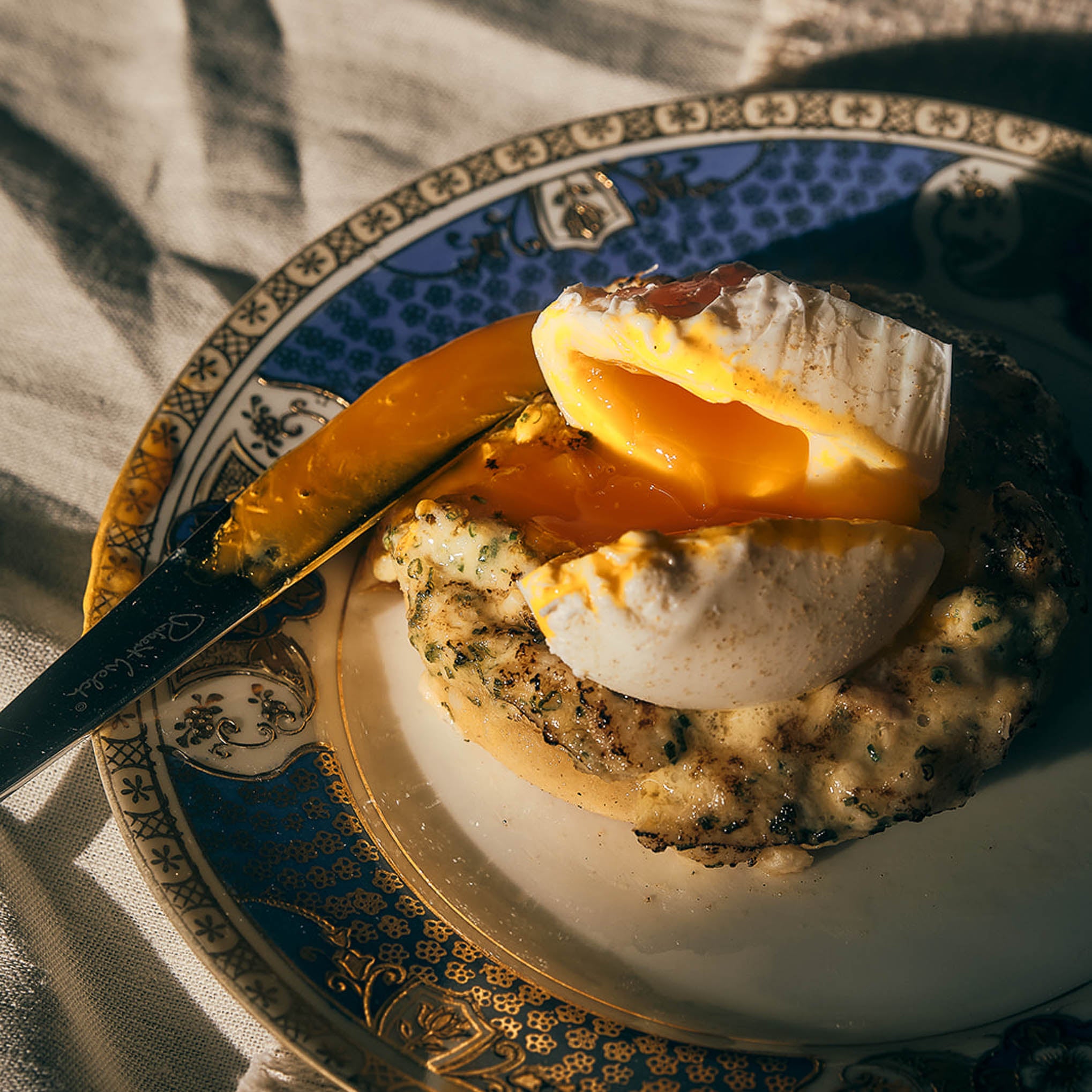 A dish crowned with an egg yolk on a blue-patterned plate