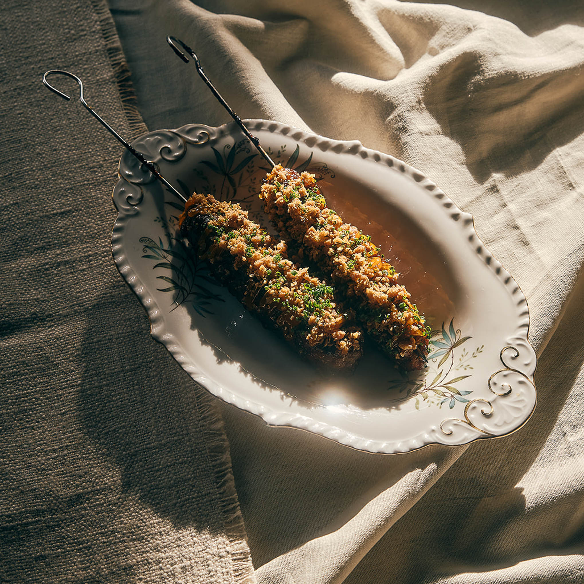 Crumbed skewers served on an oval dish