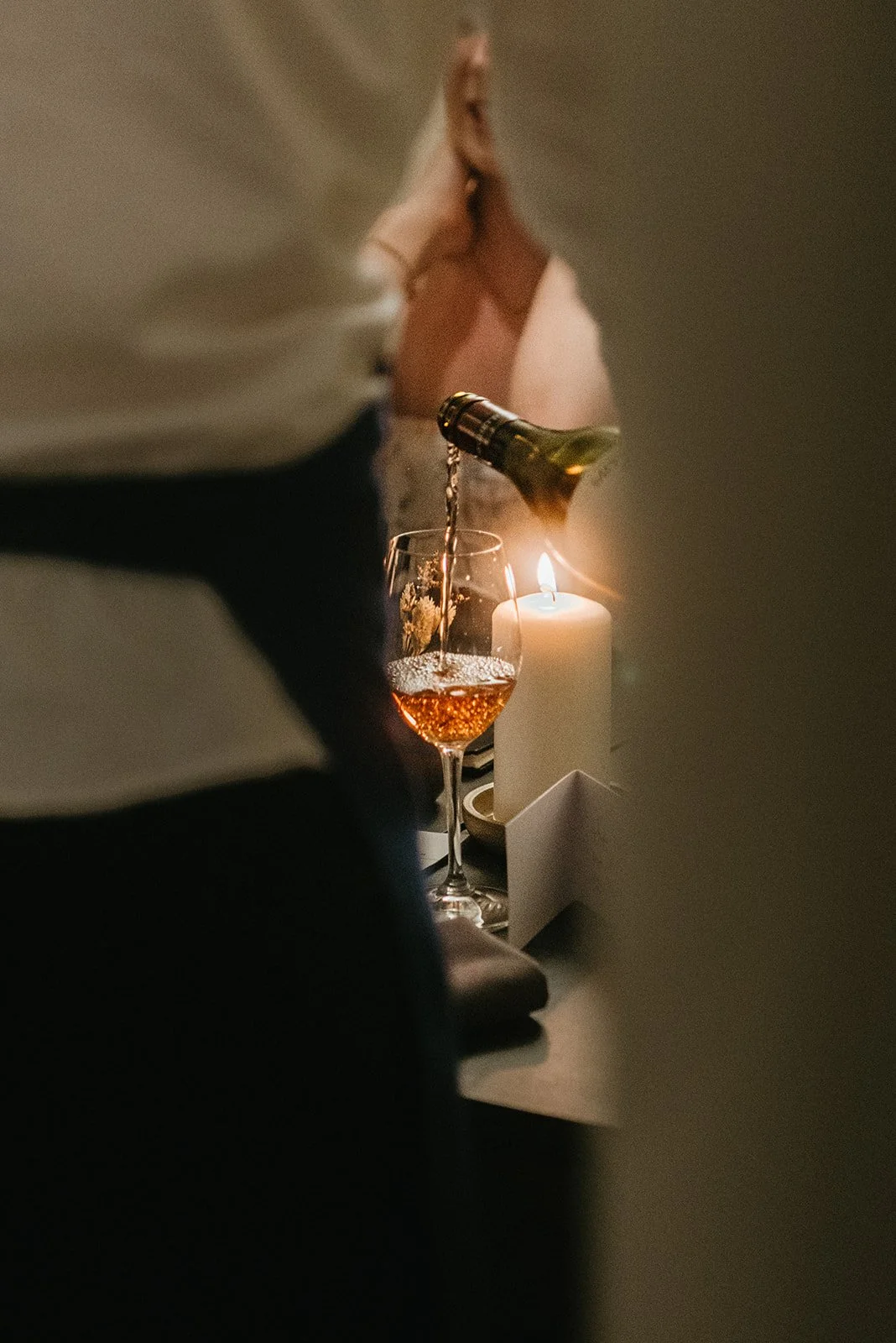 A drink poured by candlelight at the table