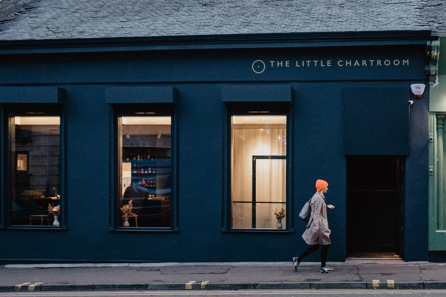 The Little Chartroom&rsquo;s deep-navy shopfront on Albert Place, lit up in the evening