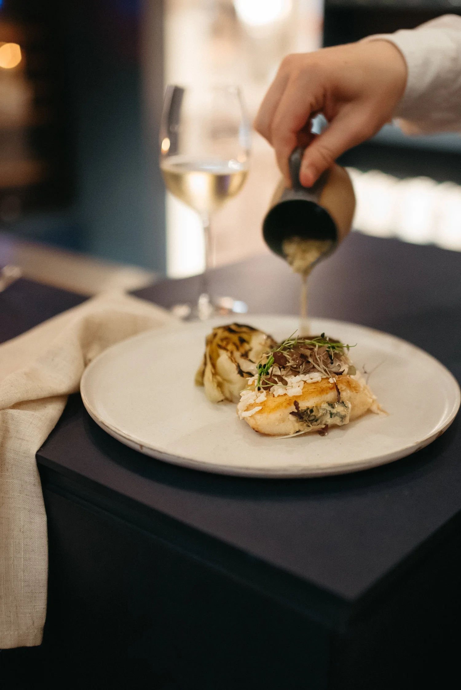 Sauce poured tableside over a plated dish